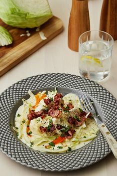 a plate that has some food on it with a fork and glass next to it