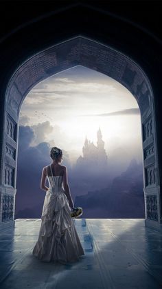 a woman in a white dress is looking out an archway at the sky and clouds