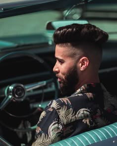 a man sitting in the driver's seat of a car with his head turned to the side