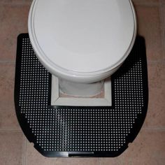 a white toilet sitting on top of a bathroom floor next to a tile flooring