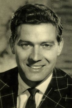 an old black and white photo of a man in a suit smiling at the camera