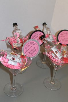 three wine glasses filled with pink confetti and personalized bottle labels on them