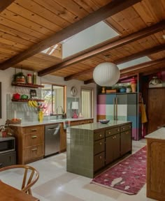 a kitchen with wooden ceiling and tile flooring