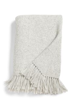 a white blanket with fringes on the bottom and one in grey, is shown