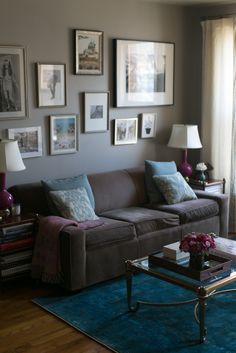 a living room filled with furniture and pictures on the wall