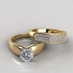 two gold wedding rings with diamonds on the top and bottom, sitting next to each other