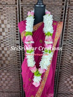 a pink sari with white flowers on it