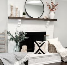 a living room filled with furniture and a fire place under a round mirror on top of a mantle