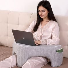 a woman sitting on a couch using a laptop