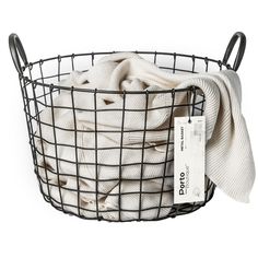 a wire basket filled with white towels and a tag on the front of it's handle