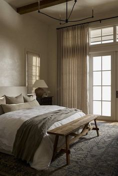 a bedroom with a large bed sitting next to a sliding glass door in front of it