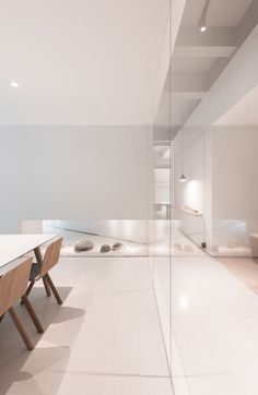 an empty room with a long table and chairs in it, next to a glass wall