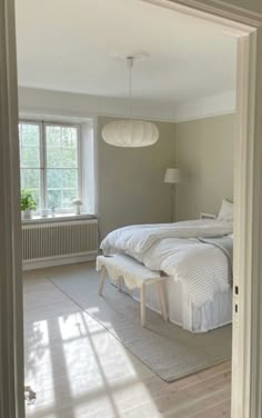 an open door leading to a bedroom with two beds and lamps on either side of the room