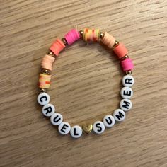 a close up of a bracelet on a wooden table with words written in small letters