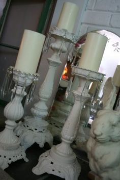 white candles are lined up next to each other on a table in front of a mirror