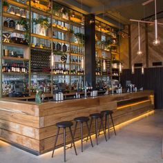 a bar with stools and shelves filled with bottles