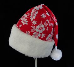 "If you are celebrating a tropical Christmas this year you may need a special hat.  This novelty Santa hat is made up in a Christmas red and white Hawaiian traditional hibiscus print cotton fabric. Hat is decorated with a snowy white faux Sherpa fur fabric turn up brim. Put Santa in a tropical island mode for that balmy warm holiday season.   The sizing on the hat is generous and will fit most adult head sizes.   The styling is a slouch cone, traditional Santa style. There is a snowy white faux Adjustable Red Christmas Hat, Red Adjustable Christmas Hat, Adjustable Red Hats For Holiday, Adjustable Red Hat For Holiday, Red Christmas Hat For Festive Occasions, Red Christmas Cap, Festive Red Adjustable Hat, Adjustable Red Hat For Festive Occasions, Red Adjustable Festive Hat