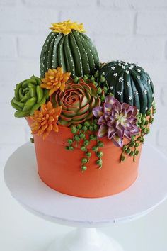 there is a cake decorated with succulents and flowers on the top of it