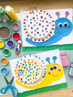 two paper plates with colorful designs on them next to craft supplies and paintbrushes