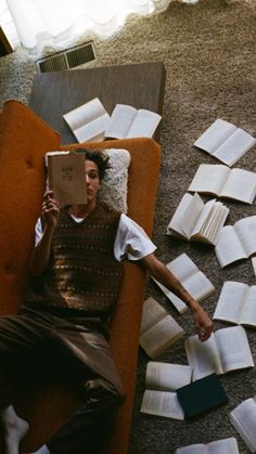 a man laying on the floor reading a book