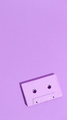 a white cassette on a purple background with two holes in the front and one hole in the back