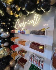 the candy wall is decorated with balloons and confetti