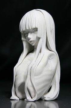 a white sculpture of a woman with long hair and bangs on her head, sitting in front of a black background