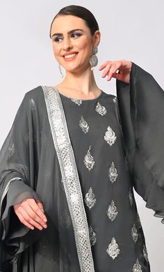 Step into the spotlight with our breathtaking 3-piece Garara Set, meticulously crafted to elevate your style to new heights. Adorned with intricate silver zari and foil work embroidery, the kurti exudes an aura of timeless elegance, while the heavy foil border on the kurta and garara hem adds a touch of opulence. Each motif tells a story of exquisite craftsmanship, shimmering gracefully with every movement. The ensemble is completed with a dupatta featuring a matching foil border, tying the look Semi-stitched Silver Anarkali Set For Festivals, Silver Anarkali Set For Eid With Traditional Drape, Silver Semi-stitched Anarkali Set For Eid, Elegant Silver Sharara With Zari Work, Festive Elegant Sets With Dabka Detailing, Elegant Festive Dabka Sets, Bollywood Style Silver Anarkali Set For Eid, Formal Silver Traditional Wear With Zari Work, Elegant Formal Sets With Mirror Work