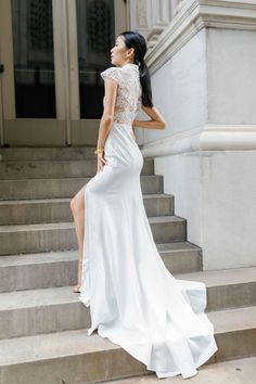 a woman in a white dress standing on some steps