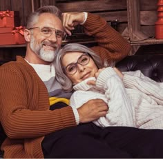 an older man and woman sitting on a couch