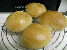 three loaves of bread sitting on top of a wire rack in front of an oven