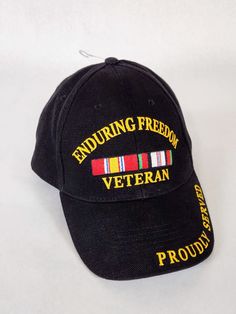 a black hat with an embroidered medal and ribbon on the side that says,'including freedom veteran proud '