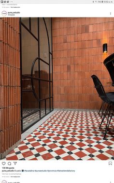 an image of a room that is decorated in red and white tiles with black chairs