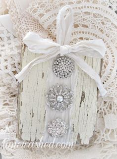 a white lace doily with flowers and pearls on it, tied in a bow