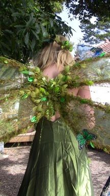 a woman in a green dress with wings