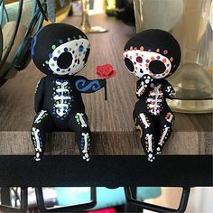 two sugar skulls sitting next to each other on a table