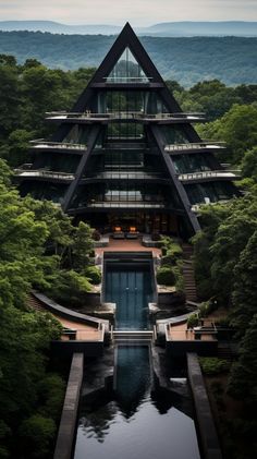 an unusual building in the middle of a forest with water running through it and trees surrounding it