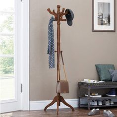 a coat rack with hats and scarves hanging on it's sides in a living room