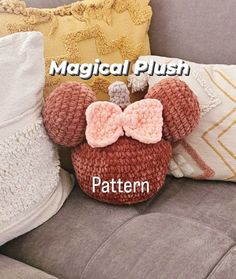 a crocheted mickey mouse pillow sitting on top of a couch