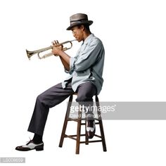 a man sitting on a stool with a trumpet in his hand and wearing a hat