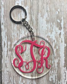 an acrylic keychain with the word monogrammed in red on it