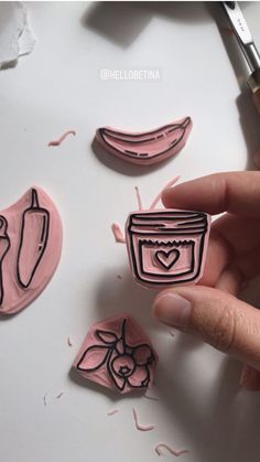 a person is holding some type of stamp that has been carved into the shape of fruit and vegetables