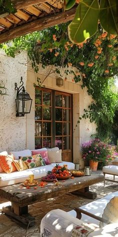 an outdoor living area with couches, tables and potted plants