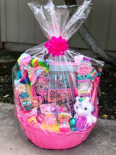 a pink basket filled with lots of toys and gifts for someone to put in it