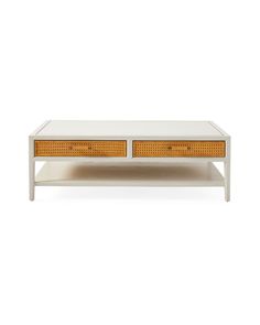 a white coffee table with two drawers and wicker inserts on the bottom shelf