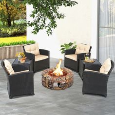 a fire pit sitting on top of a patio next to chairs and a potted plant