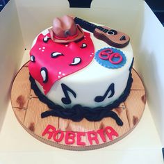 a birthday cake in the shape of a cowgirl's hat and boots on display