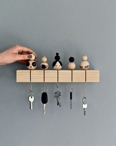 a person is holding keys on a key rack that holds several different kinds of items