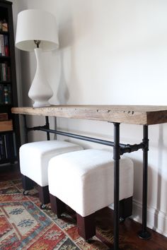 a white bench sitting next to a lamp on top of a wooden table in a living room