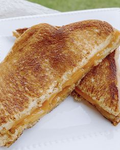 two grilled cheese sandwiches on a white plate